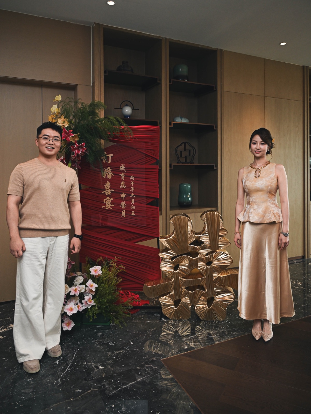 两人在订婚宴迎宾布景前的完整合影
