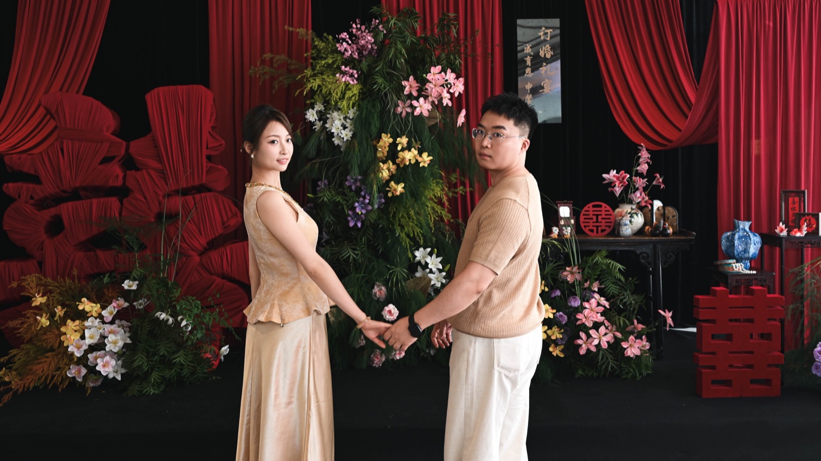 成育恩与申馨月在订婚宴布景前牵手